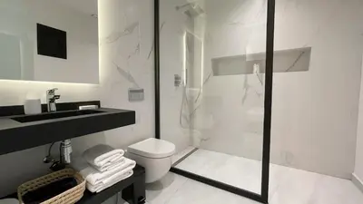a bathroom with a shower and a toilet and a sink at Villa Balzac Marrakech with heated pool in Marrakech