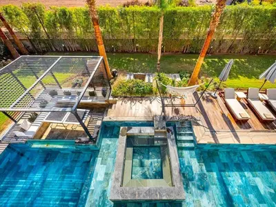 an overhead view of a swimming pool with chairs and a hammock at Le Palais Zahira & Palais Mahora 2 villas in Marrakech
