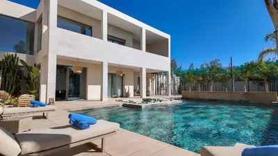 a house with a swimming pool in front of it at Beautiful AWAL Villa, 6 suites & heated pool in Marrakech