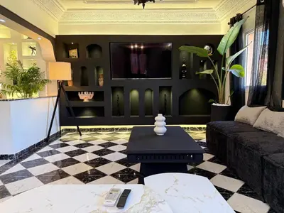 a living room with a couch and a tv at Beautiful modern triplex in Qariya Sayhia in Marrakech