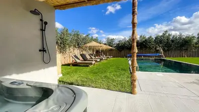 a bathroom with a bath tub next to a swimming pool at Villa JAMAL with heated pool in Marrakech in Marrakech