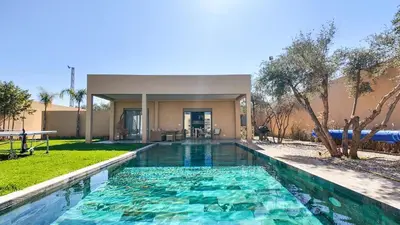 a swimming pool in front of a house at Beautiful Asma Villa with heated pool in Marrakech