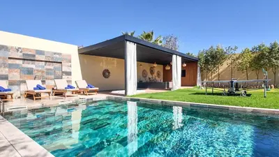 a swimming pool in front of a house at Beautiful Asma Villa with heated pool in Marrakech