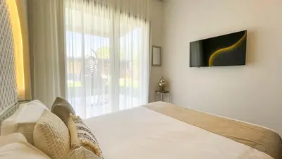 a bedroom with a bed and a tv and a window at Beautiful Asma Villa with heated pool in Marrakech