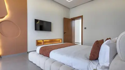 a bedroom with a bed and a tv on the wall at Villa Céleste avec piscine chauffée in Marrakech
