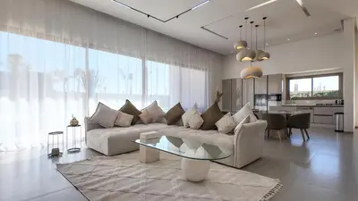 a living room with a couch and a table at Villa Céleste avec piscine chauffée in Marrakech