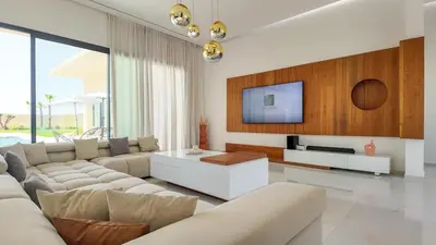 a living room with a couch and a tv at Villa Nour heated pool not overlooked in Marrakech