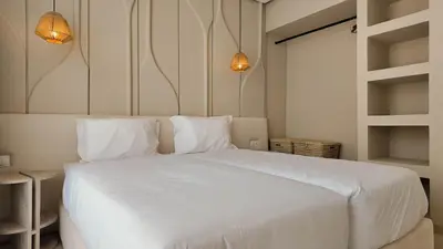 a bedroom with a large white bed with two pillows at Majorelle Bungalow - Heated pool, not overlooked in Marrakech