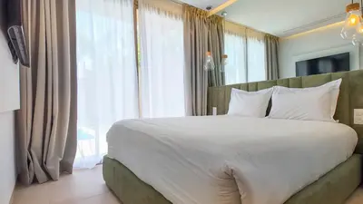 a bedroom with a large bed and a large window at Targa Bungalow - Heated pool, not overlooked in Marrakech