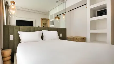 a bedroom with a large bed with white pillows at Agdal Bungalow - Heated swimming pool, not overlooked in Marrakech