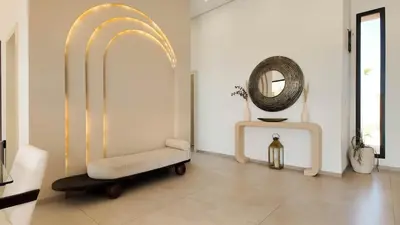 a living room with a chair and a mirror at Villa Maryam heated pool not overlooked in Marrakech