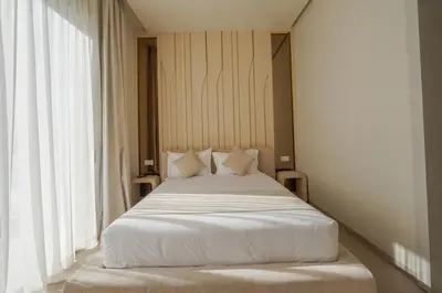 a bed with white sheets and pillows in a room at Villa Jibal heated pool not overlooked in Marrakech