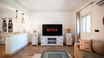 a living room with a tv and a couch at Appt Duplex dans village touristique, sublime vue, proche médina in Marrakech