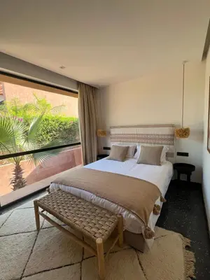 a bedroom with a large bed and a large window at Villa Bohō - 4 suites in El Rhechat
