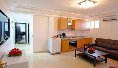 a kitchen and living room with a couch and a table at Appart Hôtel Mouna in Marrakech