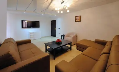 a living room with two brown couches and a table at Appart Hôtel Mouna in Marrakech