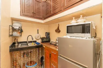 a small kitchen with a refrigerator and a sink at Dar Si Ahmed in Marrakech