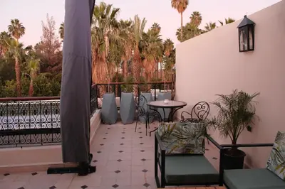 a patio with chairs and a table on a balcony at Riad Oumhani in Marrakech