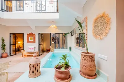 a villa with a swimming pool and a living room at Riad Bahia Burgos - Exclusive - Heated Pool & Breakfast - 15 min walk Jemaa El Fnaa in Marrakech
