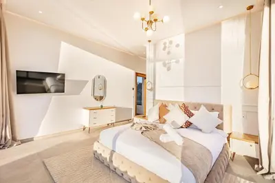 a bedroom with a bed and a tv on a wall at Beautiful Villa 15 min Center, Jacuzzi, Padel in Marrakech