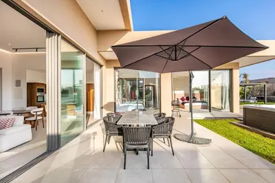 a patio with a table and chairs and an umbrella at Heated Pool Absolute Luxury in Marrakech