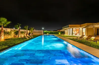 a swimming pool in a backyard at night at Prestige Villa Heated Pool Total Quiet in Marrakech