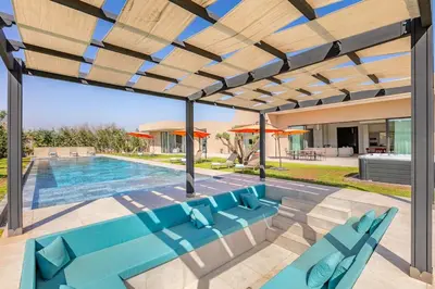 a patio with blue chairs and a swimming pool at Chic Villa Jacuzzi and Green Space in Marrakech