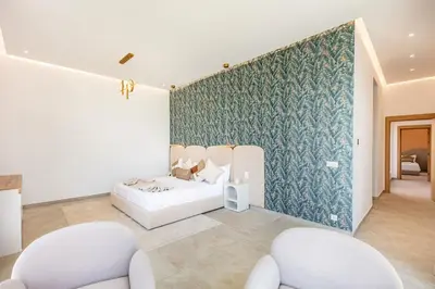 a bedroom with a bed and two chairs at Chic Villa Jacuzzi and Green Space in Marrakech