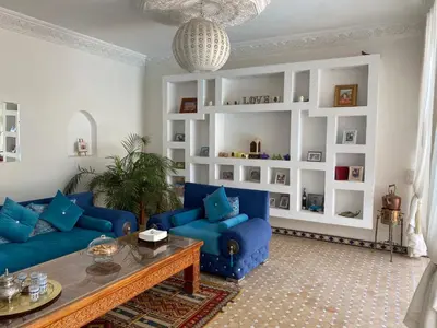 a living room with blue couches and a table at Riad El Laadel Marrakech in Marrakech