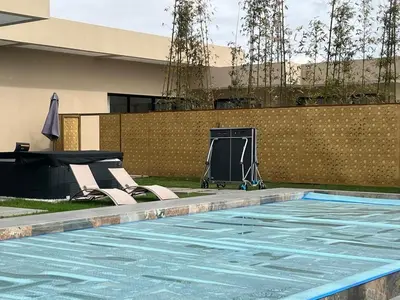 a swimming pool with two chairs and a table next to a building at Diamond Serenity House in Marrakech