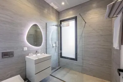 a bathroom with a sink and a shower with a mirror at Villa Magique Piscine Chauffée Et Jacuzzi in Marrakech