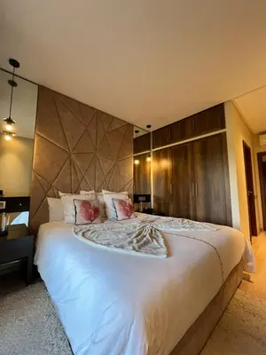 a bedroom with a large bed with white sheets and pillows at Appart Essalam 2 in Marrakech