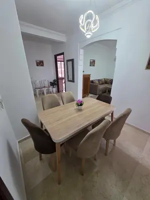 a dining room with a wooden table and chairs at apartt le Palmier de Guéliz in Marrakech