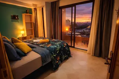a bedroom with a bed with a view of a city at Luxe Hivernage Piscine Géante & Terrasse XXL in Marrakech