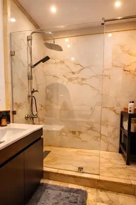 a bathroom with a shower with a glass door at Luxe Hivernage Piscine Géante & Terrasse XXL in Marrakech