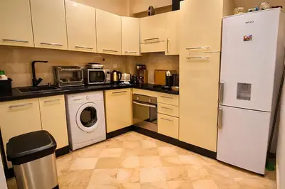a kitchen with a refrigerator and a washer and dryer at Luxe Hivernage Piscine Géante & Terrasse XXL in Marrakech