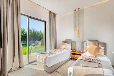 a bedroom with two beds and a large window at Modern design and jacuzzi in Marrakech