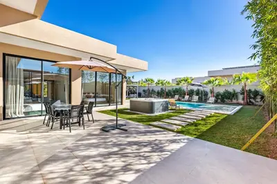 a patio with a table and chairs and an umbrella at Modern design and jacuzzi in Marrakech