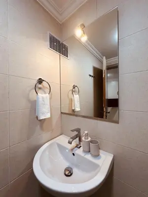 a bathroom with a white sink and a mirror at Blue and sun Majorelle comfort and spacious in Marrakech