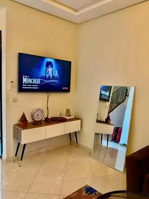 a living room with a television on the wall at Gouarial in Marrakech