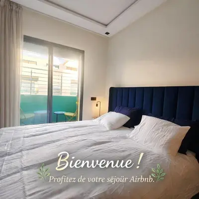 a bedroom with a large bed with a blue headboard at New comfy appartement-centre -Menara-Gueliz-aero in Marrakech