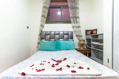a bedroom with a bed with roses on it at Heart of Gueliz - Nice 2BR Flat near Train Station in Marrakech