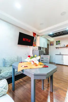 a table in a living room with a kitchen at Heart of Gueliz - Nice 2BR Flat near Train Station in Marrakech