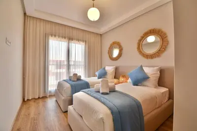 a bedroom with two beds and a couch and a mirror at Marrakech Luxury 2BR Pool View and Terrace for Remote Work in Marrakech