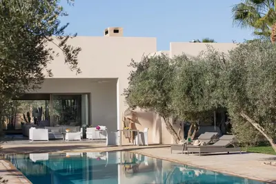 a house with a swimming pool with chairs and trees at Elegant 3-BR Villa with breakfast included in Marrakech