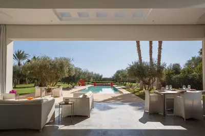 a patio with tables and chairs next to a pool at Elegant 3-BR Villa with breakfast included in Marrakech