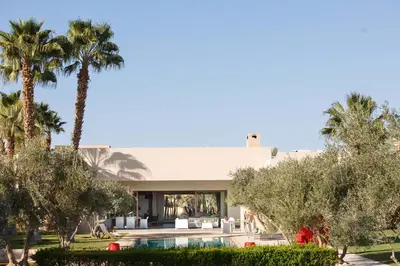 a house with a swimming pool and palm trees at Elegant 3-BR Villa with breakfast included in Marrakech
