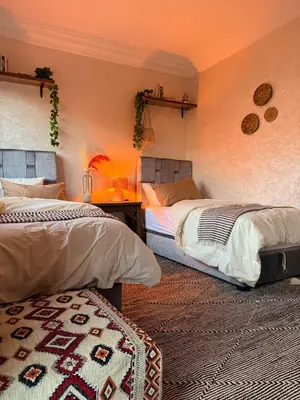 a bedroom with two beds and a rug at Charming Bohemian hideaway in Marrakech in Marrakech