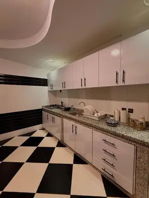 a kitchen with white cabinets and a black and white checkered floor at Charming Bohemian hideaway in Marrakech in Marrakech