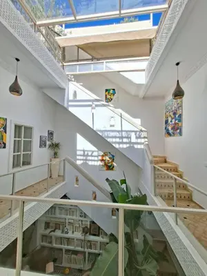 a staircase in a white building with a plant at Riad Millefeuilles in Marrakech